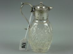 A small cut glass claret jug with electroplated mounts, 14 cms high