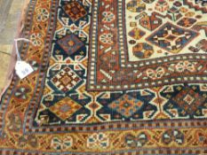 An antique Eastern woollen carpet, triple bordered with multi-section panels of stylized shapes,