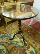 A 19th Century circular mahogany tripod table with shaped and turned centre pedestal and three pad