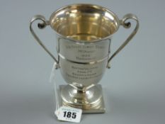A hallmarked silver twin handled pedestal trophy by the Goldsmiths and Silversmiths Company,