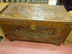 An Oriental camphorwood deep carved chest, the top carved with beasts, birds and fish amongst trees,