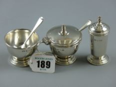 A hallmarked silver cruet set of lidded salt pot with blue glass liner, open mustard bowl and