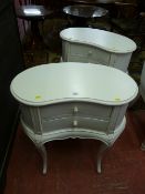 A pair of cream painted French style kidney shaped two drawer chests on shaped supports, 70 x 64