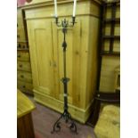 A Victorian cast iron and brass twin branch candle stand with a twisted column on wrought iron legs,