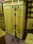 A Victorian cast iron and brass twin branch candle stand with a twisted column on wrought iron legs,