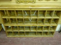 An antique pine pigeonhole rack of thirty sections, 102 x 162 cms, 25 cms deep approximately