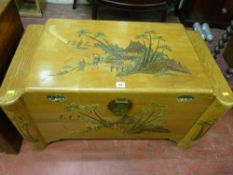 An Oriental camphorwood lidded chest with stained carving, 50 x 90 cms
