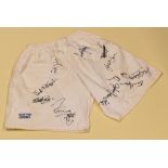 PAIR OF RUGBY SHORTS SIGNED BY APPROXIMATELY 28 VARIOUS PLAYERS worn in a special commemorative