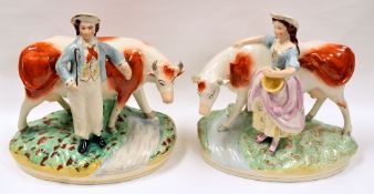 A PAIR OF NINETEENTH CENTURY STAFFORDSHIRE COW AND FIGURE MODELS each on naturalistic oval bases