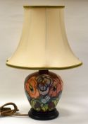 MODERN MOORCROFT TABLE-LAMP with red reserve and decorated with tube-lined flowers all-round,