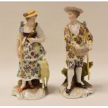 A PAIR OF CONTINENTAL PORCELAIN GARDENER FIGURINES being a lady and gentleman, the lady with a