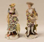 A PAIR OF CONTINENTAL PORCELAIN GARDENER FIGURINES being a lady and gentleman, the lady with a