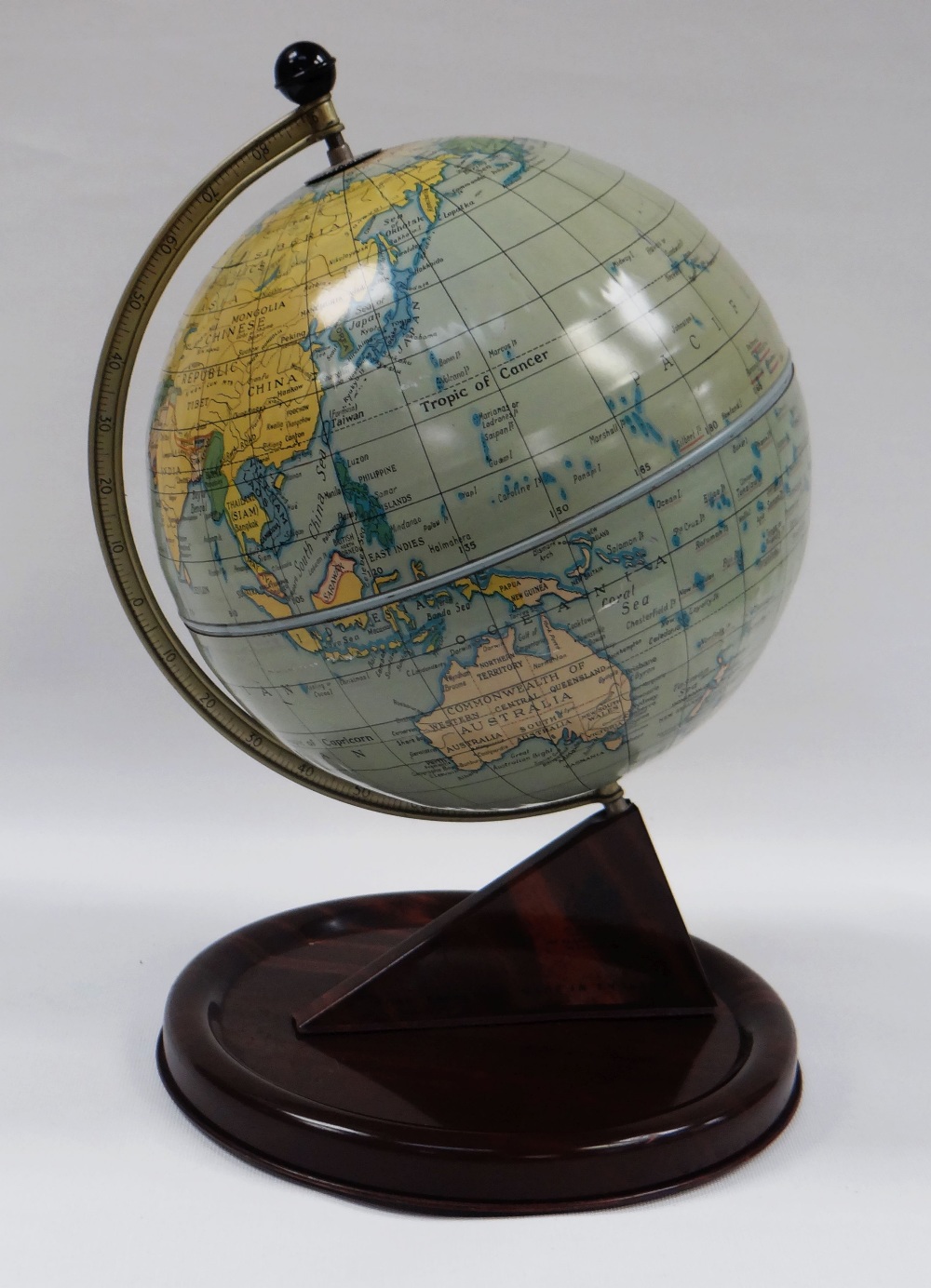 A CHAD VALLEY TINPLATE TERRESTIAL GLOBE, the faux-wood stand with printed detail, 28cms high,