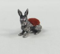 A SMALL NOVELTY SILVER PIN-CUSHION IN THE FORM OF A SEATED RABBIT with realistic fur detail, 3cms