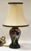 A MODERN MOORCROFT TABLE LAMP decorated with tube-line flowers and stems on a blue ground,