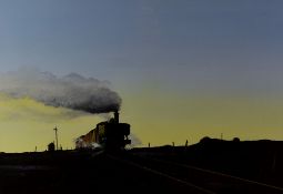 LAURENCE ROCHE oil on card - steam train pulling freight cars, entitled verso 'Dawn Freight', signed