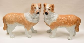 A PAIR OF WHITE AND BROWN STAFFORDSHIRE DOGS IN STANDING POSITION with painted faces, 29cms