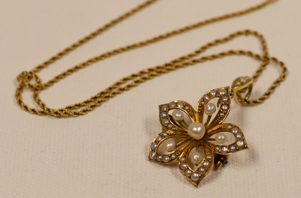 9CT YELLOW GOLD & SEED PEARL PENDANT of floral form and on a fine rope-chain necklace