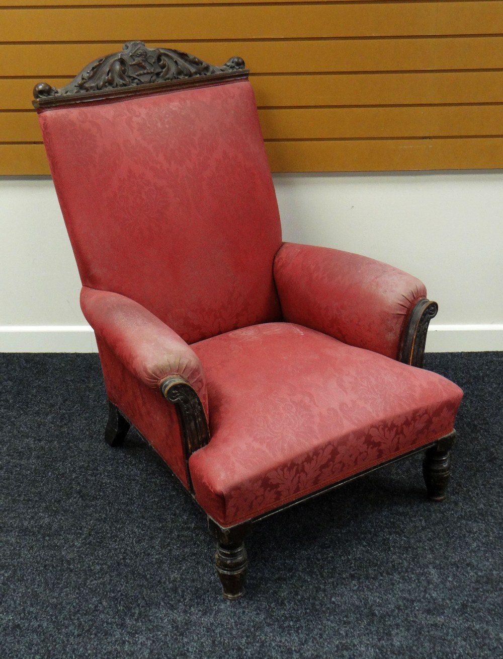 AN UPHOLSTERED ARMCHAIR with carved heraldic lion frieze to rail, 108 x 72 cms