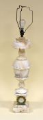 A LARGE ALABASTER ANTIQUE TABLE-LAMP composed of a plinth base mounted with yellow metal laurel