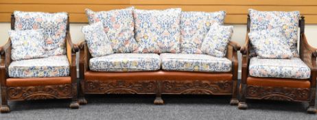 A BERGERE STYLE THREE PIECE SUITE in floral upholstery with carved base and rails