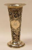 A SILVER PIERCE-WORK VASE decorated with raised scrolls and flowers and of tapered form with a