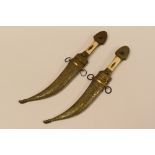 PAIR OF TURKISH DECORATIVE KNIVES with brass scabards, brass and bone handles and having curved