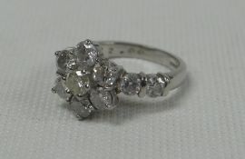 AN ELEVEN DIAMOND FLORAL-CLUSTER RING in white-gold and including two diamonds to each shoulder, 6.