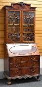 AN EDWARDIAN MAHOGANY BUREAU BOOKCASE having a base with three long drawers with carved frieze on