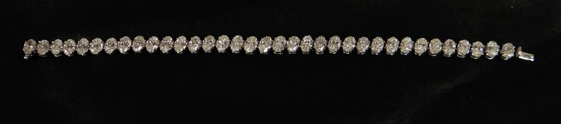 DIAMOND TENNIS BRACELET in 18ct white gold with thirty-five oval fine diamonds, accompanied by