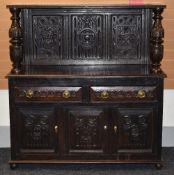 A NINETEENTH CENTURY AND EARLIER CARVED OAK SIDEBOARD the base with three cupboard doors and two