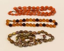 THREE STRANDS OF BEADS including agate and believed red amber