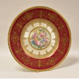 A MINTON DISPLAY PLATE having a crimson and gilded border and with centre painted flower display,
