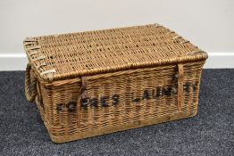 A VINTAGE WICKER LAUNDRY BASKET with Forres Laundry stencilled to the front, 72 x 30 cms