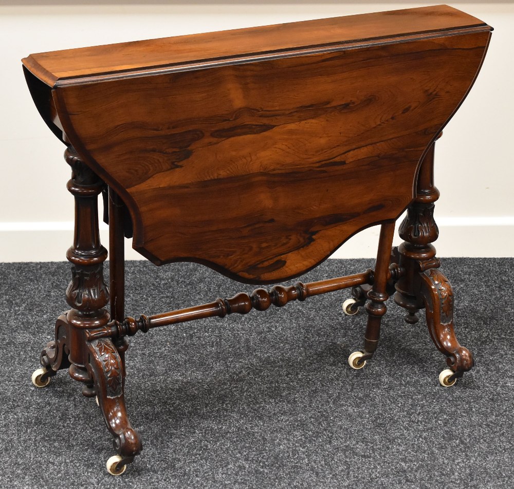 FINE QUALITY ROSEWOOD SUTHERLAND TEA TABLE with a shaped top and carved legs on original castors, 90