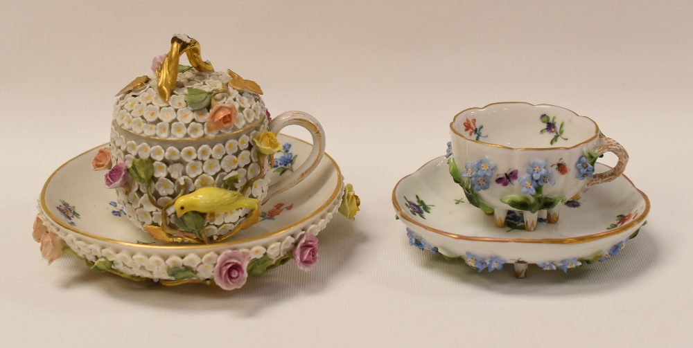 A MEISSEN FLORAL-ENCRUSTED CHOCOLATE-CUP, LID AND SAUCER AND A MEISSEN FLORAL-ENCRUSTED TEACUP AND