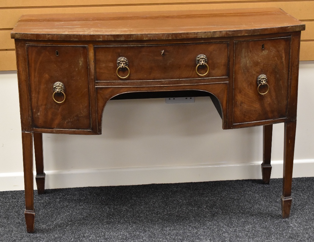 A REGENCY-STYLE MAHOGANY BOW FRONTED SIDE BOARD on raised legs with two drawers either side of a