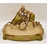 ROYAL DUX POTTERY CENTREPIECE BASIN in the form of two figures sat upon rocks with a water vessel,