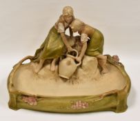 ROYAL DUX POTTERY CENTREPIECE BASIN in the form of two figures sat upon rocks with a water vessel,