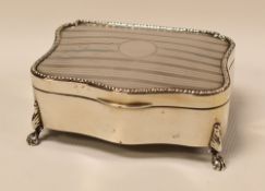 SILVER RING-BOX of shaped-rectangular form raised on four claw feet, machine-turn decoration and