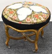 CIRCULAR CONCAVE FOOTSTOOL on gilded supports with castors and cross stitched patterned top, 60 x 48