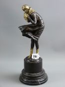 An Art Deco style bronze study of a young woman battling with a windy day on a stepped circular