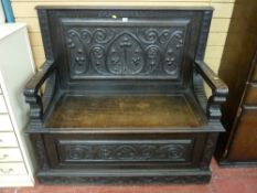 A late 19th Century carved oak box seat hall bench with gothic style floral carved panels and carved