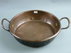 An antique copper twin handled dish, 33.5 cms diameter