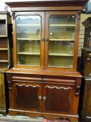 A Victorian mahogany two door cwpwrdd gwydr having an inverted stepped crown, twin glazed top