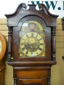 An oak and mahogany mid 19th Century longcase clock having an arched hood with painted dial, rolling