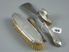 A silver handled shoe horn, a silver handled manicure knife, a silver backed dressing table brush