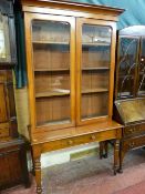 A Victorian mahogany single drawer side table with bookcase top having twin glazed doors and