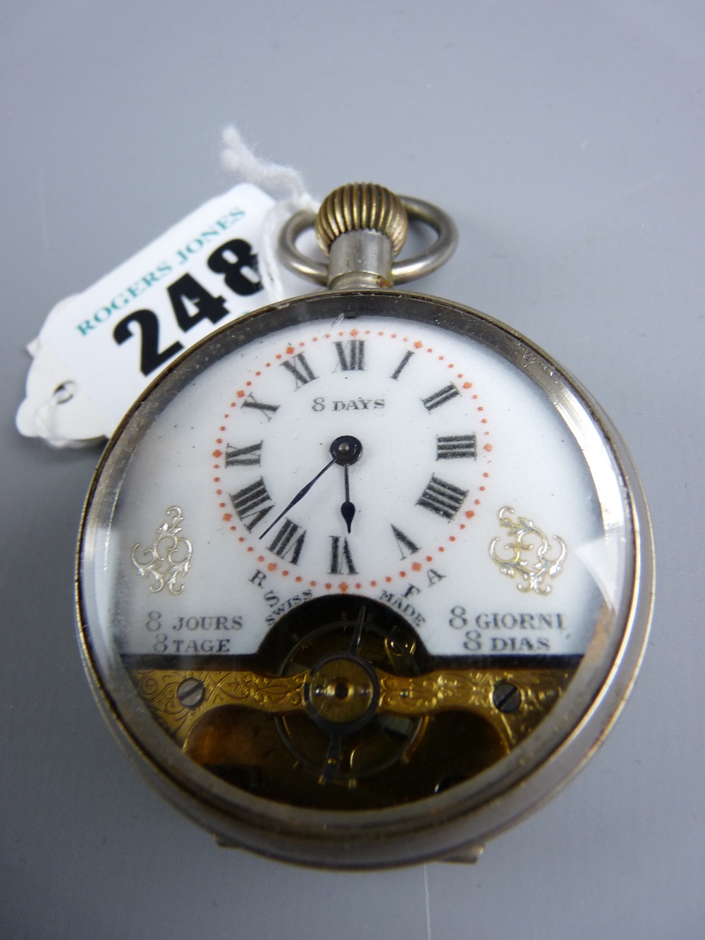 An eight day Swiss open faced pocket watch in a white metal case, gilt chased movement cover and