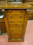 A late Victorian oak Wellington chest of seven drawers with turned wooden knobs and hinged locking